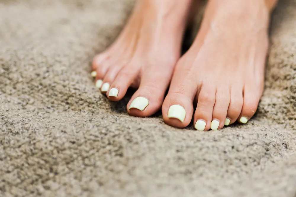 Stopy po pedicure z pomalowanymi paznokciami